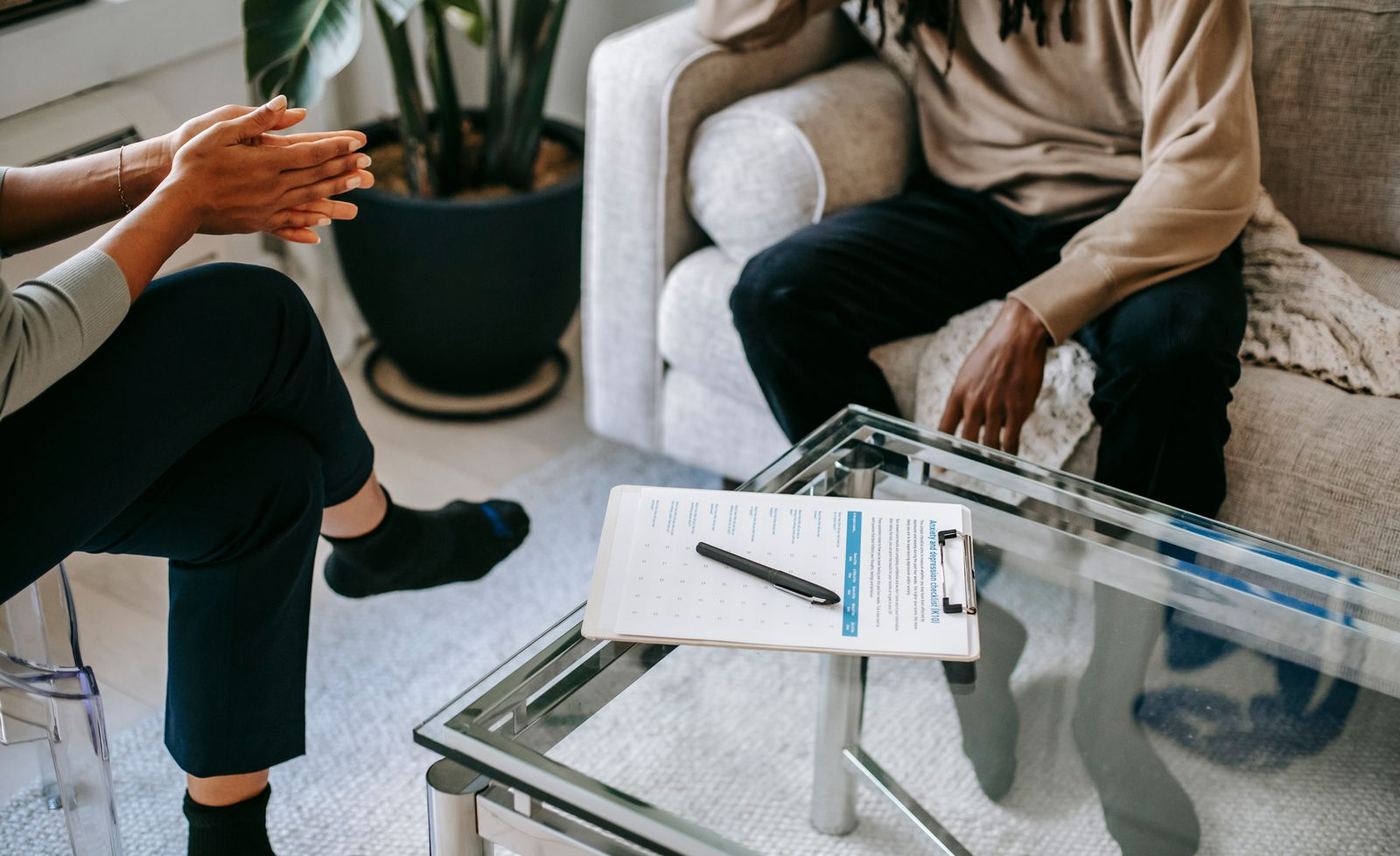 A clinician meeting with a patient across a low table